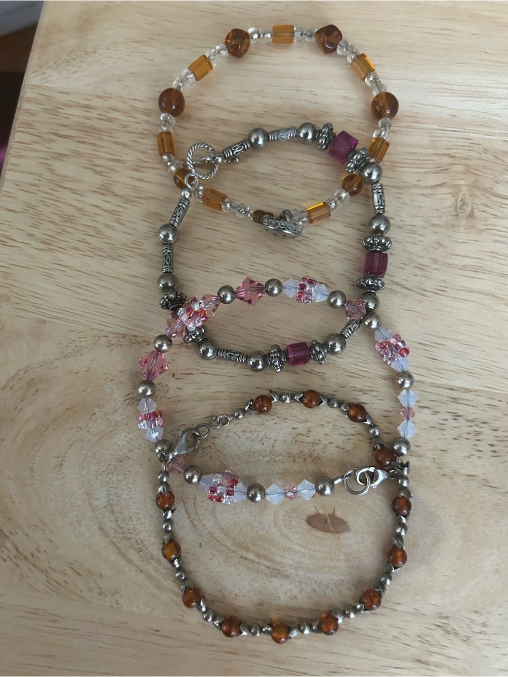 Four beautiful beaded bracelets with silver color beads and clasps.